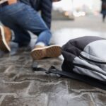 Man with backpack felling on slippery sidewalk in winter closeup
